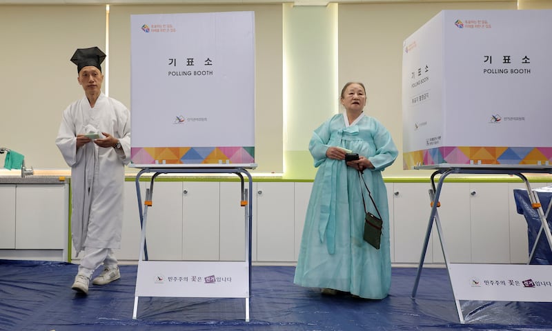 People wearing traditional attire cast their votes at a polling station in Nonsan, South Korea (Kim June-beom/Yonhap via AP)