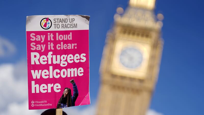 A placard is held aloft at a protest against the Illegal Migration Bill in Parliament Square, Westminster (James Manning/PA)