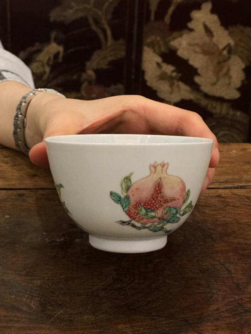 The cups feature a painting of a pomegranate spilling seeds.