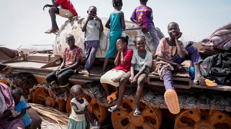 Children sit and play on the remains of a tank at the river port in Renk, South Sudan (Sam Mednick/AP/PA)