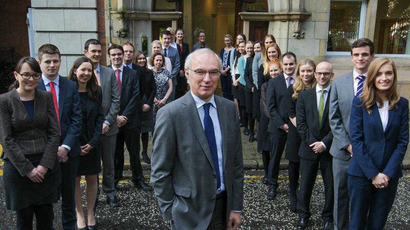 Michael Johnston, managing partner of Carson McDowell, with some of the 33 new employees who have joined the firm. Picture: Brian Thompson 