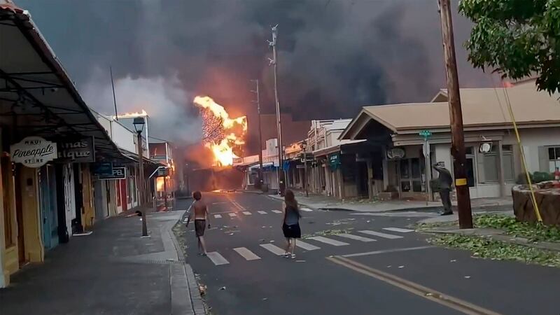 People watch as smoke and flames fill the air from raging wildfires on Front Street in Lahaina, Maui (Alan Dickar via AP)