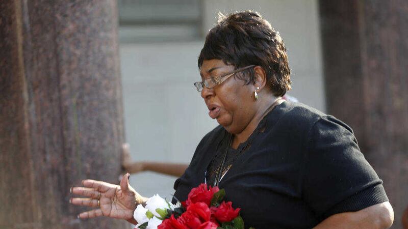 Mary Triplett arrives with flowers at a candlelight vigil for Baton Rouge police officer Montrell Jackson, outside Istrouma High School, where he graduated in 2001. Picture by Gerald Herbert, Associated Press 