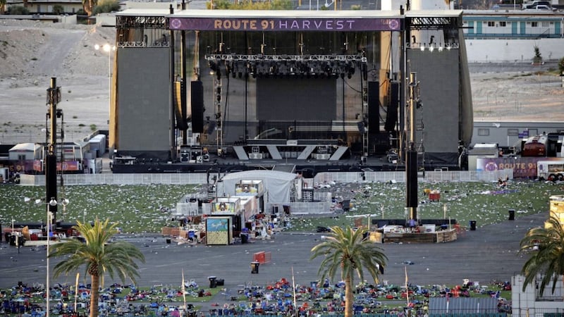 Debris litters festival grounds across the street from the Mandalay Bay resort and casino, in Las Vegas. Authorities said Stephen Craig Paddock broke windows on the casino and began firing with a cache of weapons, killing dozens and injuring hundreds at a music festival at the grounds PICTURE: John Locher/AP 