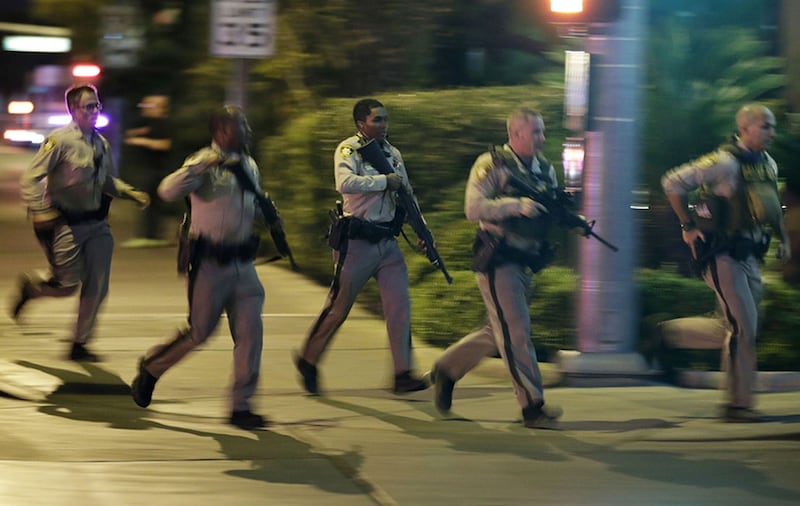 Police run to cover at the scene of a shooting near the Mandalay Bay resort and casino on the Las Vegas Strip&nbsp;