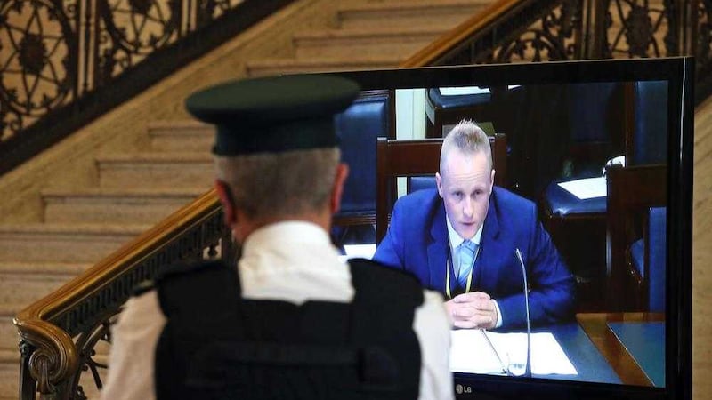 A PSNI officer watches Jamie Bryson on a TV screen in the Great Hall at Stormont appearing before the finance committee&#39;s Nama inquiry in September 2015. Picture Mal McCann 