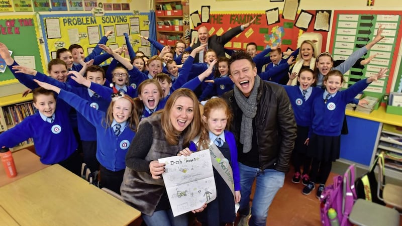 Stephen Clements and Cate Conway from Q Radio pictured with Lucy Lyons and her P6 class of St Mary&#39;s Primary School, Ballygawley 