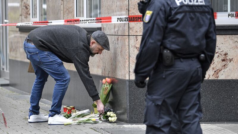 A man places flowers near a hookah bar where several people were killed on Wednesday night in Hanau, Germany, Thursday, Feb. <br />20, 2020. AP Photo/Martin Meissner&nbsp;