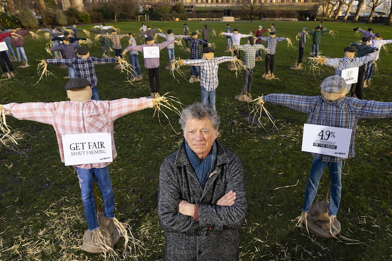 Riverford founder Guy Singh-Watson in front of 49 scarecrows outside Parliament