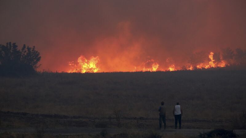 People watch the flames during a wildfire near the north-eastern town of Alexandroupolis (InTime News via AP)