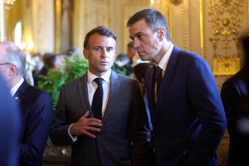 French President Emmanuel Macron, left, speaks with Spain’s Prime Minister Pedro Sanchez during a reception at the Royal Palace prior to an EU summit (Olivier Hoslet/AP)