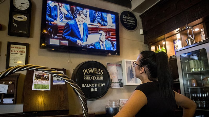 A waitress in the Balrothery Inn, Balbriggan, Co Dublin watches Minister for Finance Paschal Donohoe deliver the 2019 Budget&nbsp;