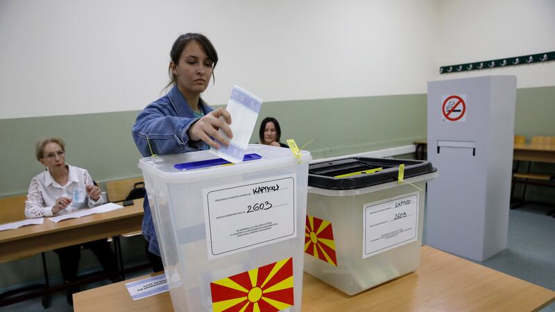 A woman casts her ballots for the parliamentary election and the presidential runoff, at a polling station in Skopje, North Macedonia (Boris Grdanoski/AP)