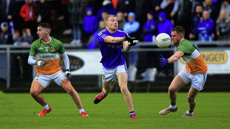 Coalisland&#39;s Peter Herron pops the ball off as Ruairi Loughran and Ruairi Slane come in to challenge for Carrickmore. Picture by Seamus Loughran. 