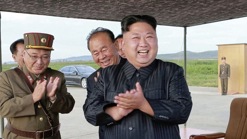 North Korean leader Kim Jong Un celebrates the test launch of an intermediate range Hwasong-12 missile 
