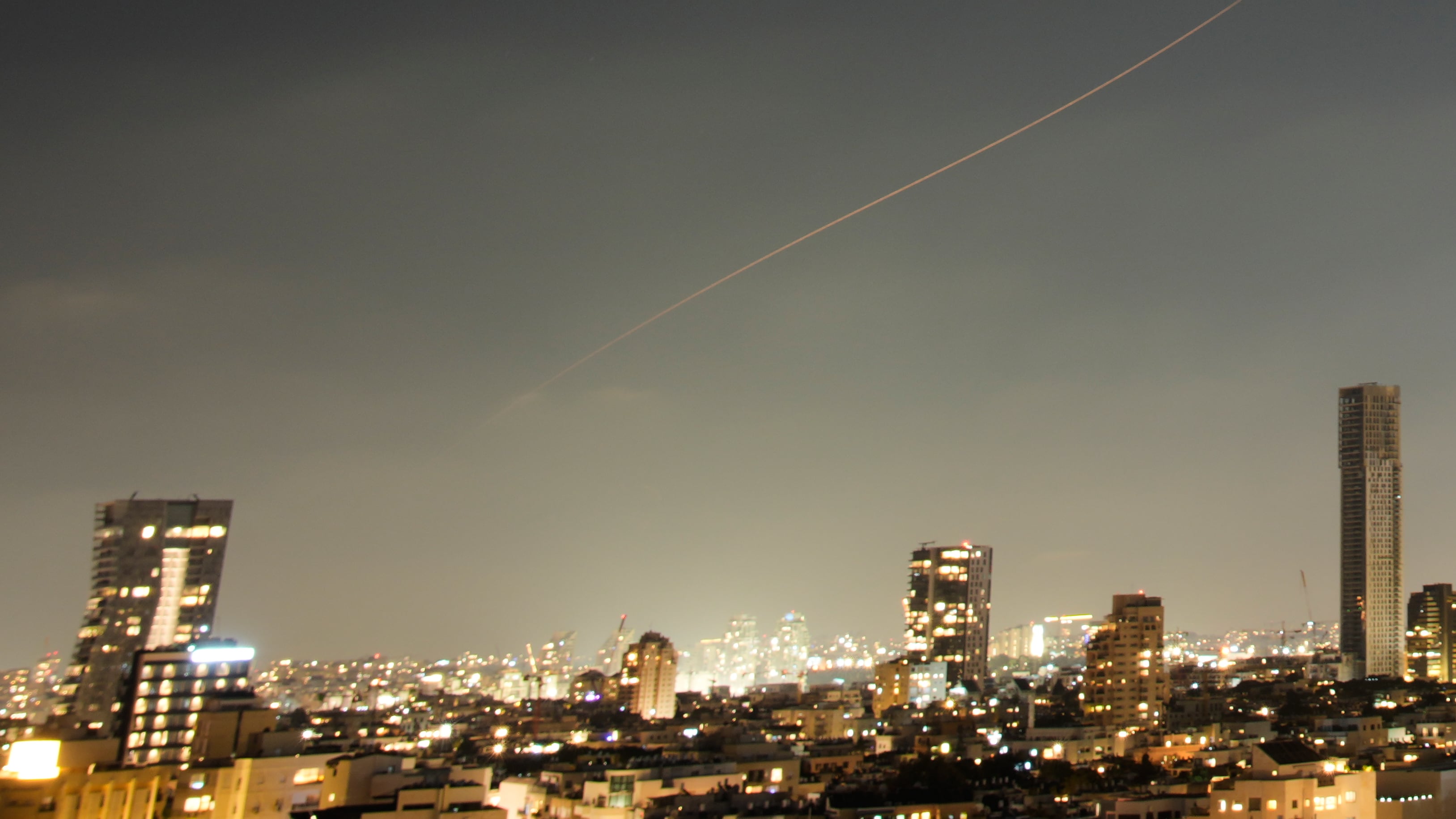 A projectile streaks through the sky over central Israel during an Iranian missile attack (Ohad Zwigenberg/AP)