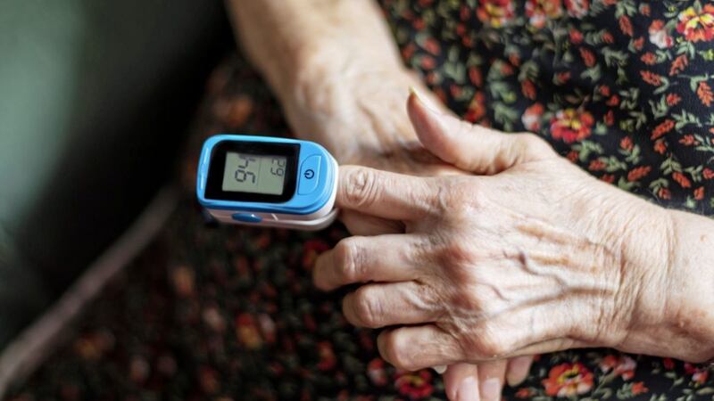 A woman measures her blood oxygen level with a pulse oximeter 