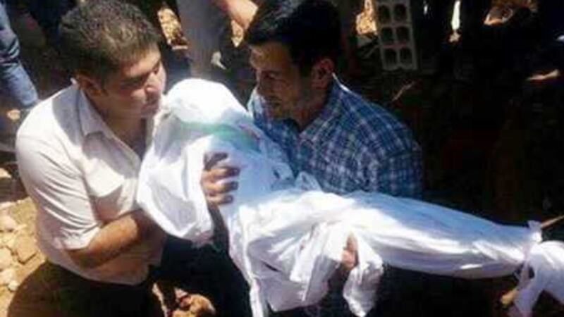 Abdullah Kurdi cradles the body of one of his young sons at their funeral. The boys drowned along with their mother as they tried to reach Europe in a dinghy