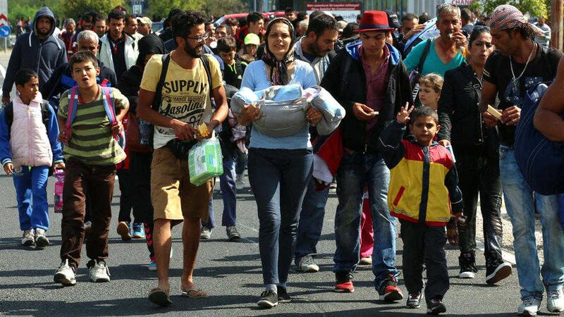 Migrants and refugees cross the border between Hungary and Austria, near Nickelsdorf, Austria yesterday. Austrian police say more than 3,000 migrants crossed into Austria overnight at Nickelsdorf, the main border point with Hungary. Picture: AP /Ronald Zak) 