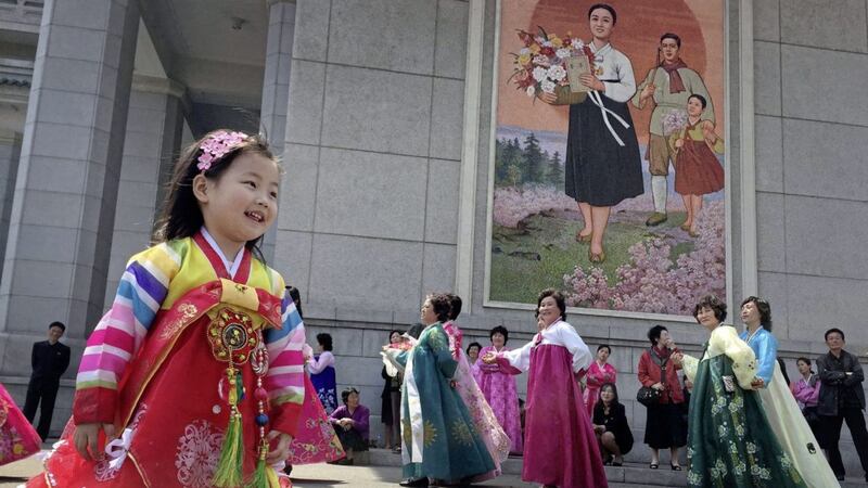 A young girl watches as North Korean men and women take part in a mass dance on Tuesday in Pyongyang, North Korea Picture by Eric Talmadge/AP 