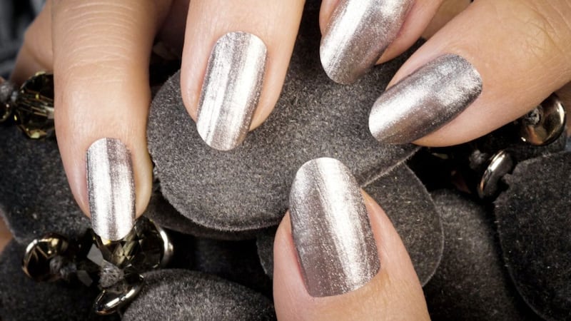 A manicured hand with silver metallic nails is part of the strobing technique 