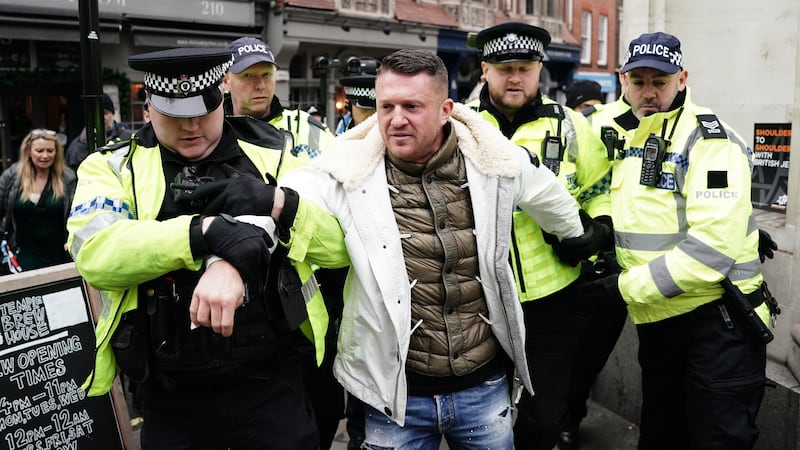 Tommy Robinson is led away by police officers as people take part in a march against antisemitism in London (Jordan Pettitt/PA)