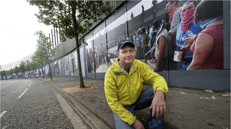Photographer Kai Wiedenhofer at his new exhibition erected along a peace wall in Belfast 