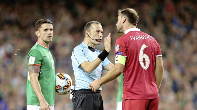 Referee Cuneyt Cakir speaks to Serbia&#39;s Branislav Ivanovic during Tuesday night&#39;s clash in Dublin 