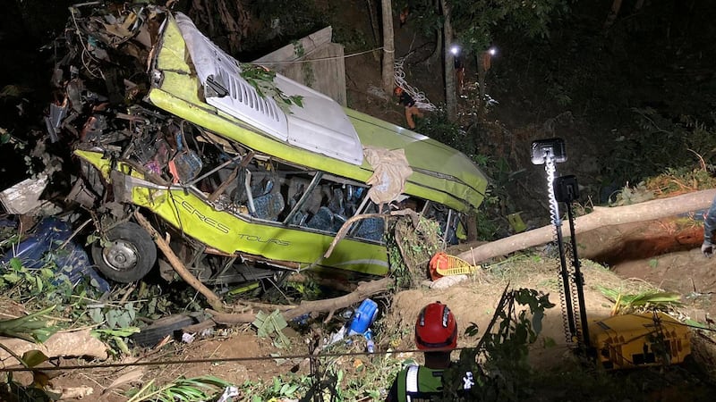 The bus lost control while negotiating a downhill curve and plunged into a deep ravine (Iloilo City Disaster Risk Reduction and Management Office – Urban Search and Rescue Unit via AP)