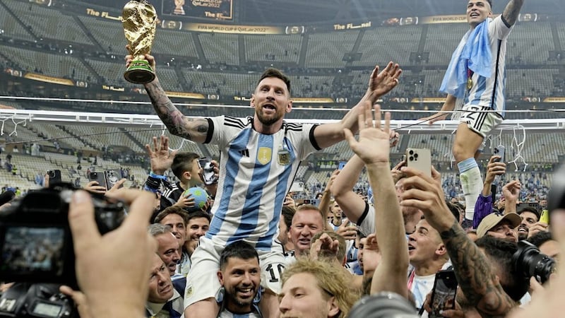Argentina&#39;s Lionel Messi celebrates with the trophy in front of the fans after winning the World Cup Final.