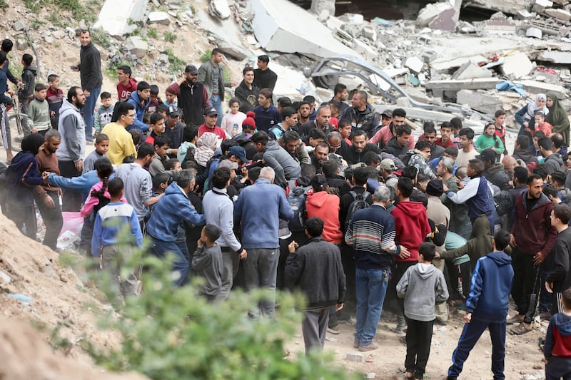 Palestinians rush to collect humanitarian aid air-dropped into Gaza City on Sunday (Mohammed Hajjar/AP)