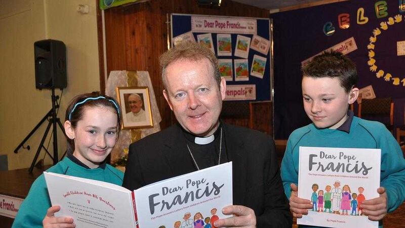 Archbishop Eamon Martin reads to Erin and Eoin, P7 pupils at St Patrick&#39;s PS Armagh. Picture by Liam McArdle 