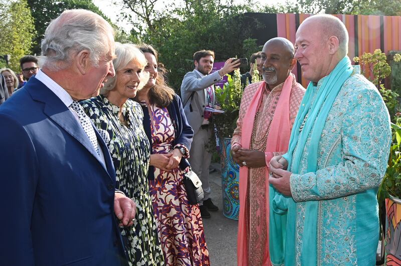 The King and Queen speak with Manoj Malde, an ambassador for inclusivity, and Clive Gillmor following their traditional Hindu ceremony marriage in the Eastern Eye Garden of Unity at Chelsea last year