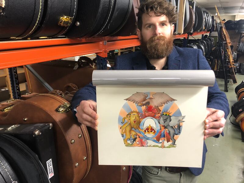 Auctioneer Luke Hobbs with David Costa's original artwork for the 1976 Queen album A Day At The Races (Gardiner Houlgate/PA)