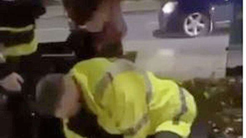 Footage appears to show a PSNI member restraining a man by the throat