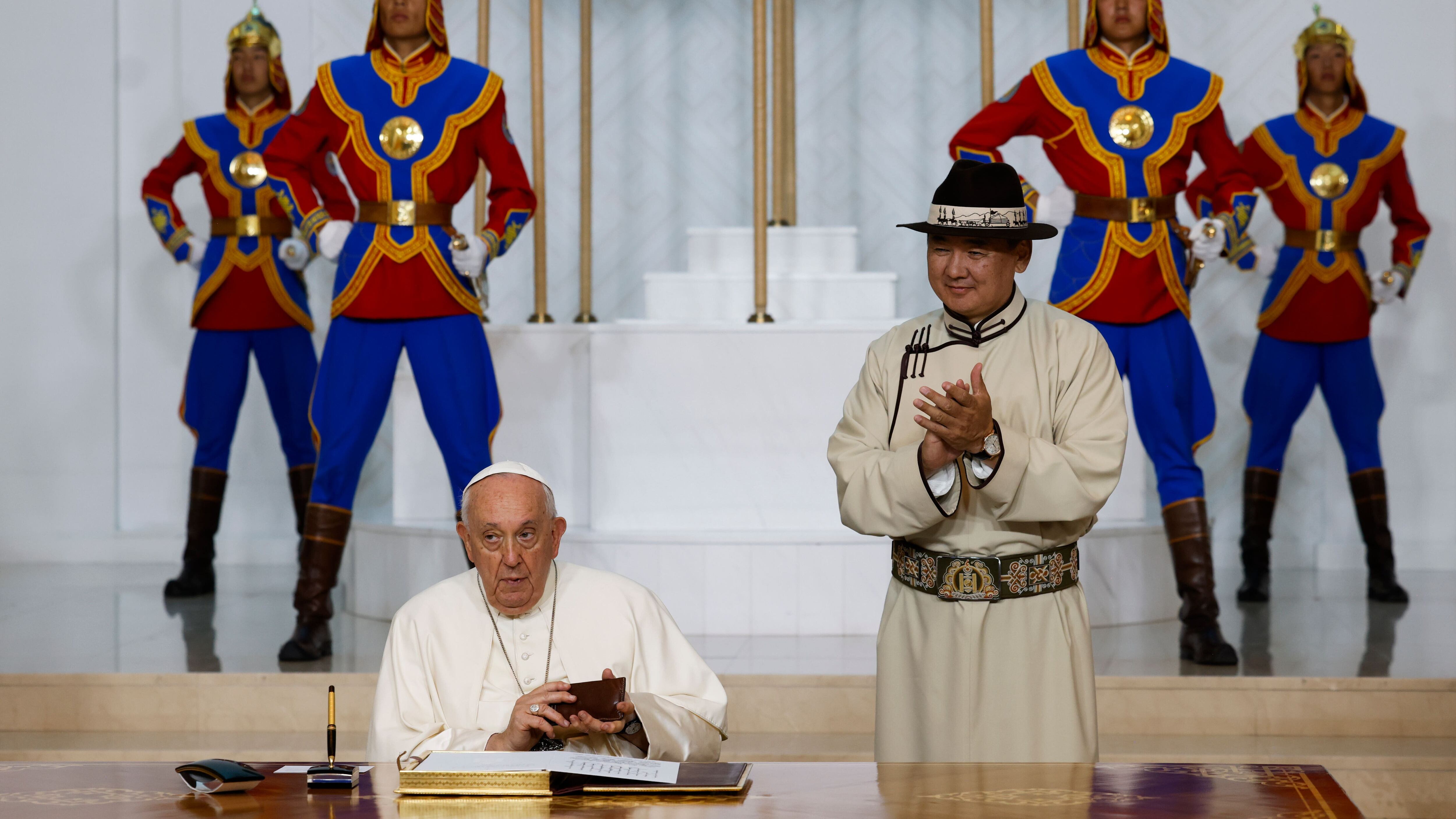 Mongolian President Ukhnaagin Khurelsukh, right, claps Pope Francis (AP Photo/Remo Casilli, pool)