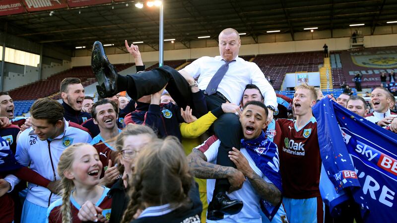 Burnley manager Sean Dyche is hoisted by his players as they celebrate promotion after the Sky Bet Championship match against QPR at Turf Moor on Monday<br />Picture by PA