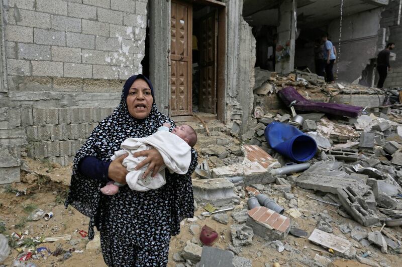 Palestinians evacuate a building destroyed in the Israeli bombardment of the Gaza Strip in Rafah. PICTURE: AP PHOTO/HATEM ALI 
