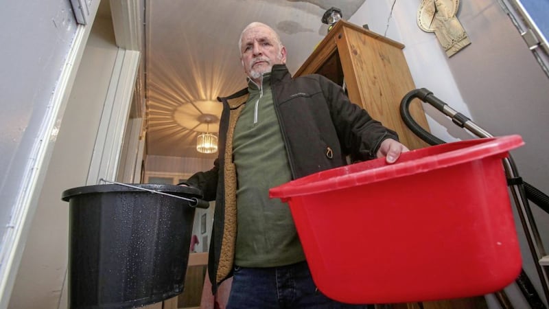 Liam Seangh&aacute;n &Oacute; hAirmheadhaigh uses buckets to catch rain water in Maeve House in New Lodge. Picture by Mal McCann. 