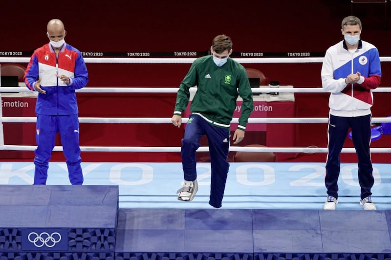 Bronze medal winner Ireland&#39;s Aidan Walsh, center, wears a medical boot on his foot as he mounts the podium for the medal award ceremony for the men&#39;s welterweight 69-kg boxing competition at the 2020 Summer Olympics, Tuesday, Aug. 3, 2021, in Tokyo, Japan. (AP Photo/Frank Franklin II) 