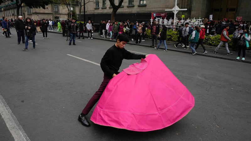 Juan Pablo Vargas makes matador cape movements during a demonstration outside the Supreme Court building in Mexico City (Fernando Llano/AP)