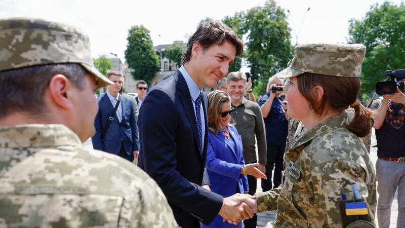 Mr Trudeau speaks with Ukrainian soldiers as he visits the Wall of Remembrance, in Kyiv (Pool via AP)