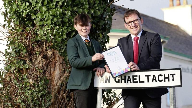 Col&aacute;iste Feirste pupil Stephen Mac Br&aacute;daigh-Mag Fhinn receives his top candidate certificate from Justin Edwards, chief executive of CCEA. Picture by Mal McCann 