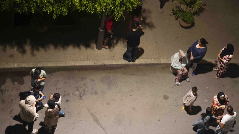 People take shelter and check for news on their mobile phones after an earthquake in Rabat (Mosa’ab Elshamy/AP/PA)