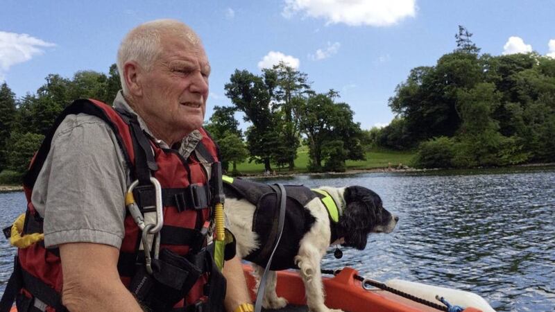 Lead QUB researcher Dr Neil Powell training dog Fern on the lake 