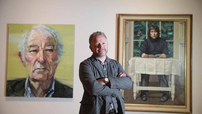 Artist Colin Davidson at the Ulster Museum as the first and last Heaney portraits hang side by side. Picture by Hugh Russell 
