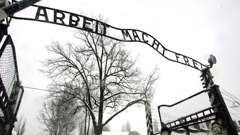 Visitors walk through the entrance gate of the Auschwitz Nazi concentration camp in Oswiecim, southern Poland. The German writing reads &#39;Work will set you free&#39;. Picture by AP Photo/Herbert Knosowski 