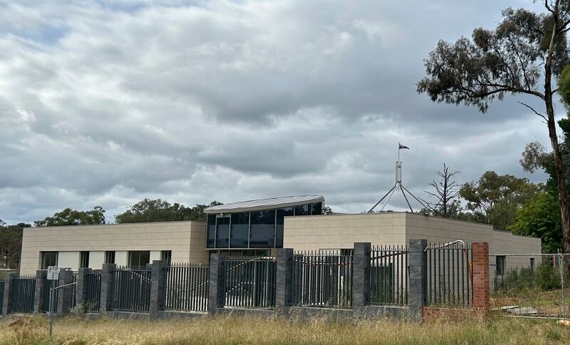 The Australian flag flies on Parliament House, seen behind an unoccupied building on the grounds of a proposed new Russian embassy near the Australian Parliament in Canberra, Feb. 28, 2023
