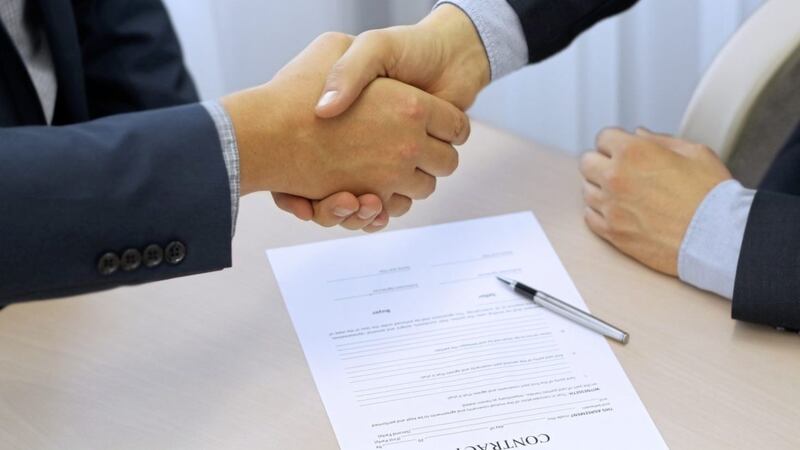 Close-up image of a firm handshake between two colleagues after signing a contract 