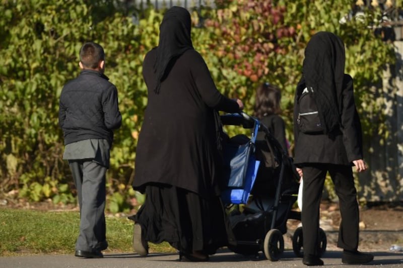A Muslim family wearing hijabs walk through Small Heath in Birmingham